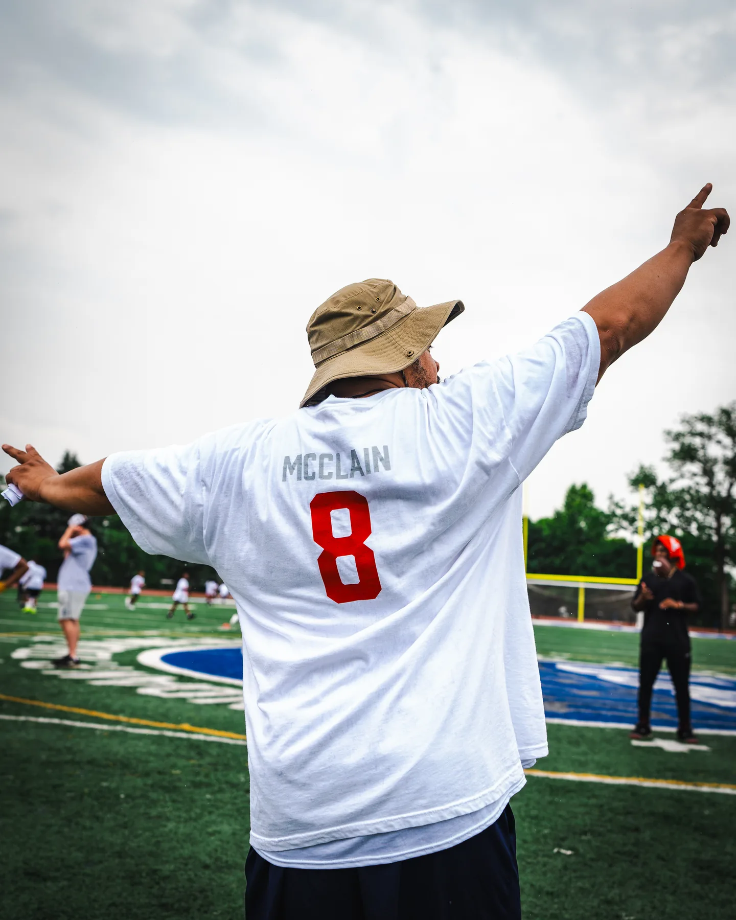A young fan in a McClain number eight jersey celebrates on the sideline at the Jaylen McClain Youth Football Camp.