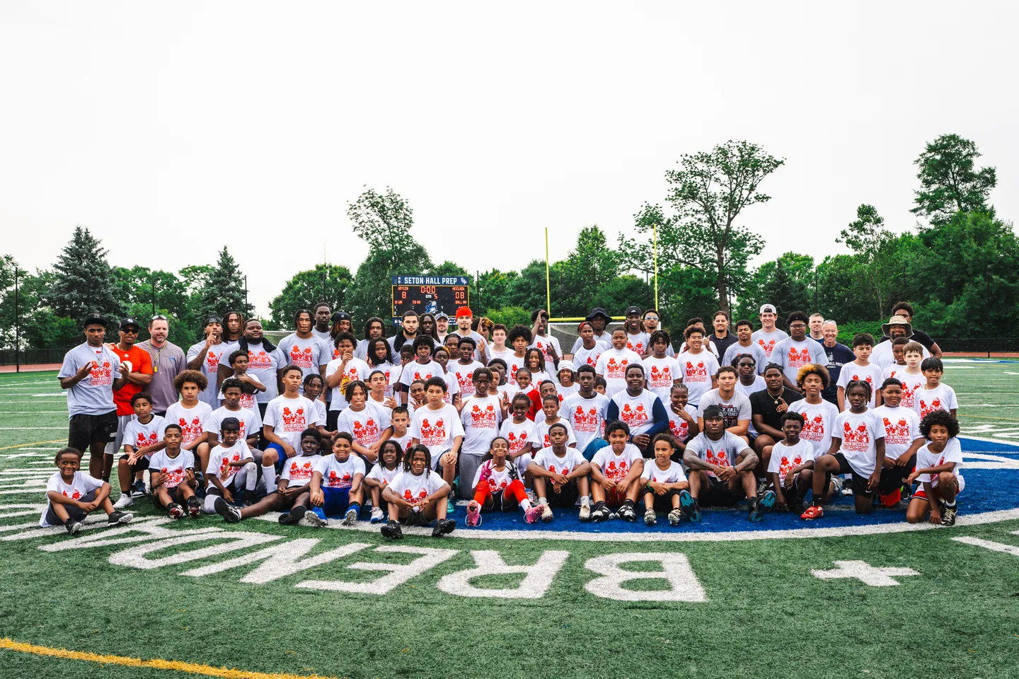 Campers and coaches gather for a group photo on the field at the Jaylen McClain Youth Football Camp.