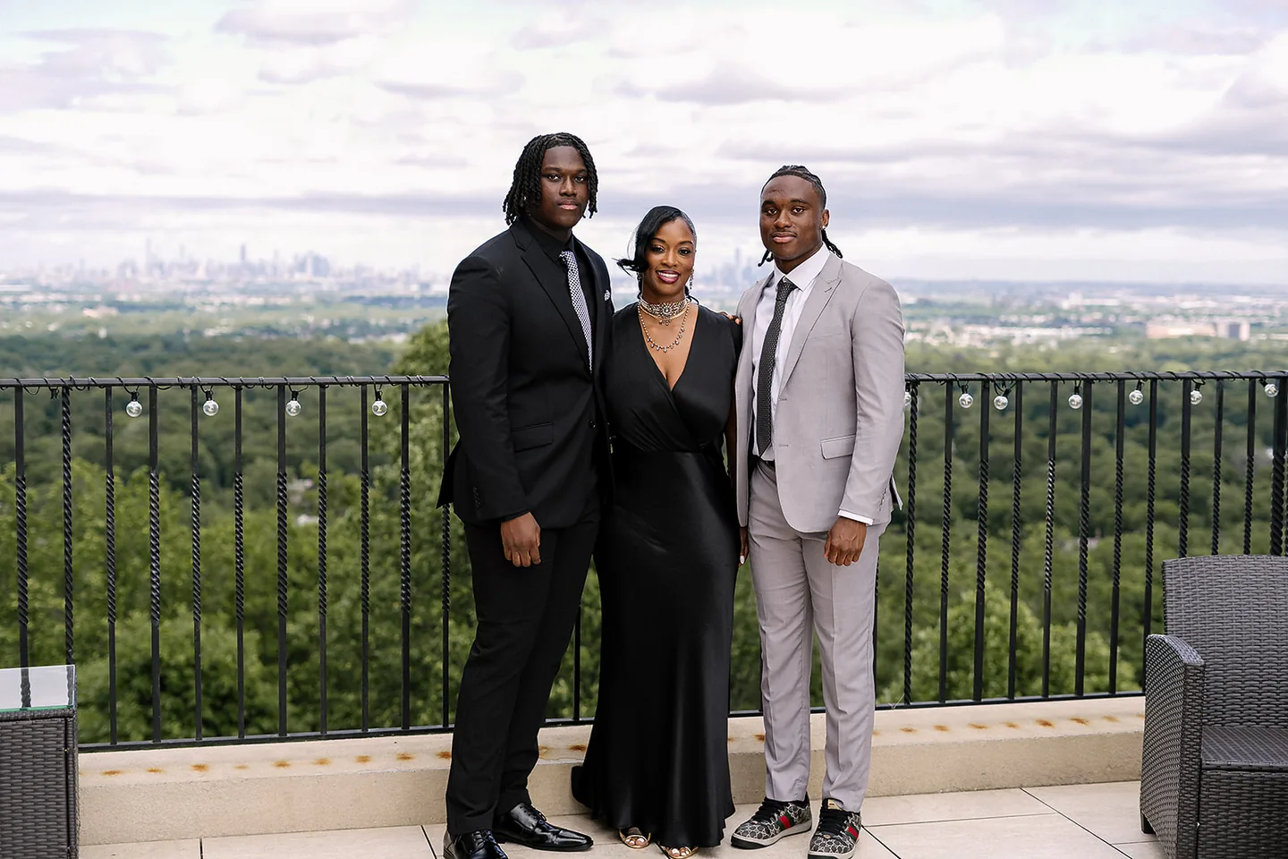 Jaylen McClain with family on The Highlawn's rooftop terrace, the city skyline behind them.