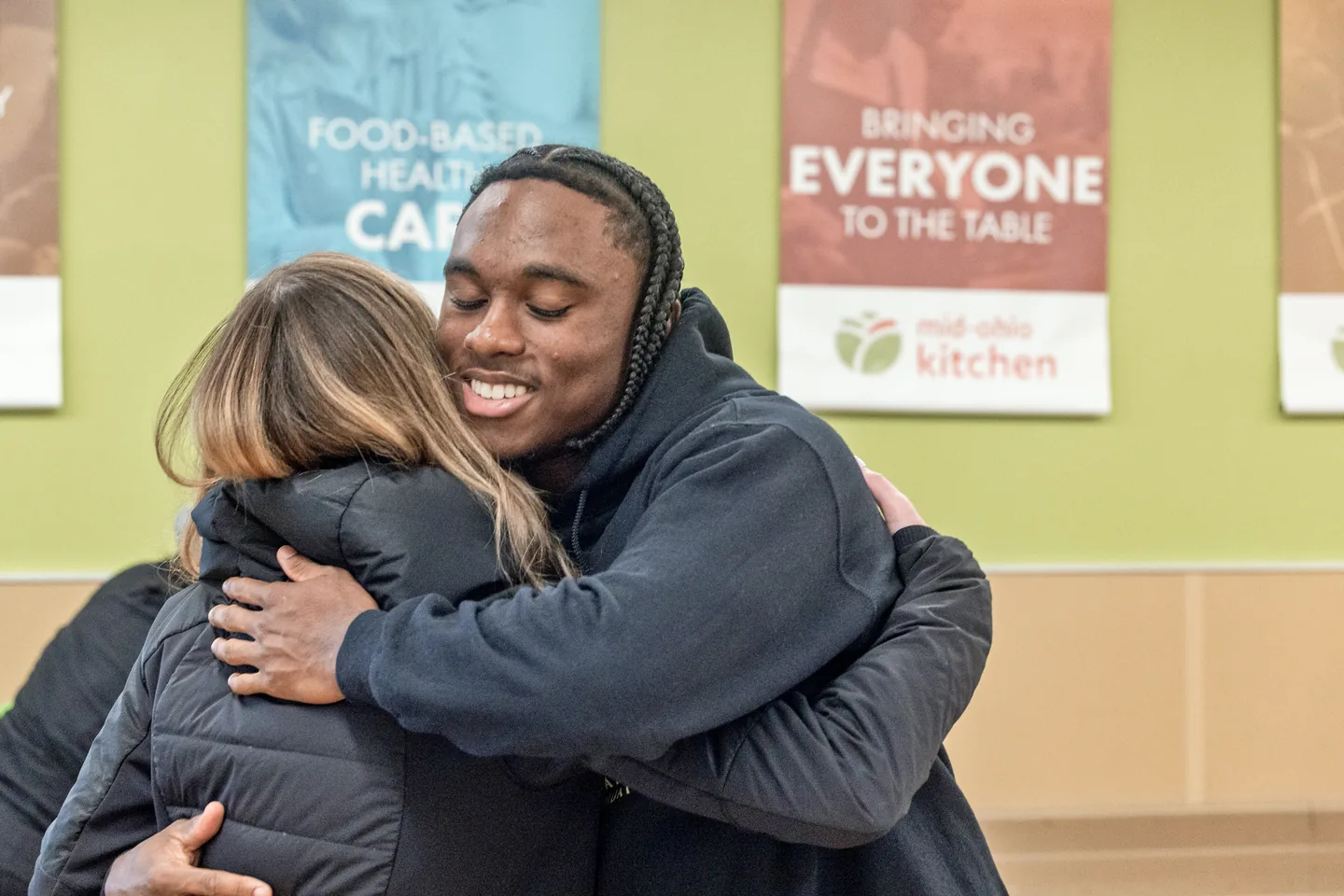 Jaylen McClain hugs a Mid-Ohio Market team member during the grocery giveaway.
