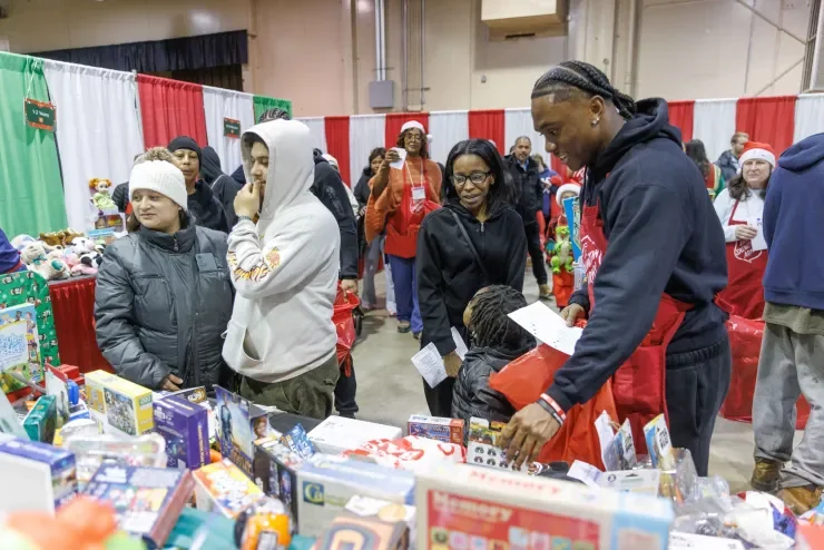 Jaylen McClain hands a toy to a family at the Salvation Army distribution.