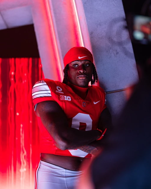 Jaylen McClain, arms crossed, lit in red in the tunnel before a game.